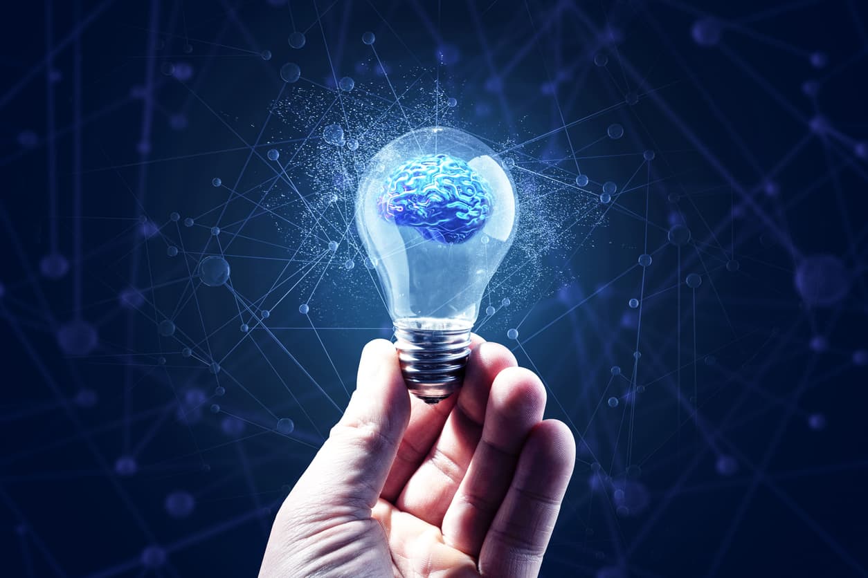 Decorative. Hand holding a lightbulb with brain, ai-neural net background.